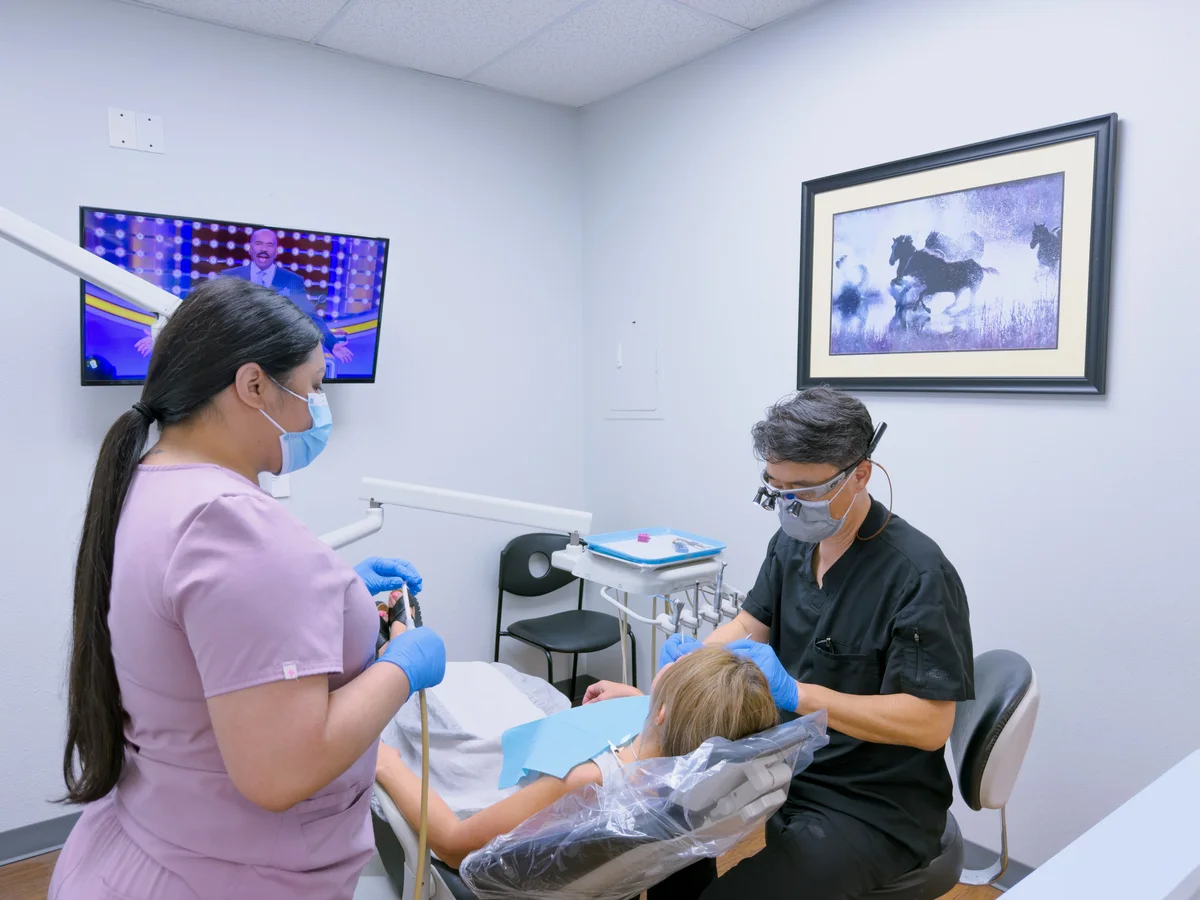 The dental team caring for a patient at Arlington Dental Associates